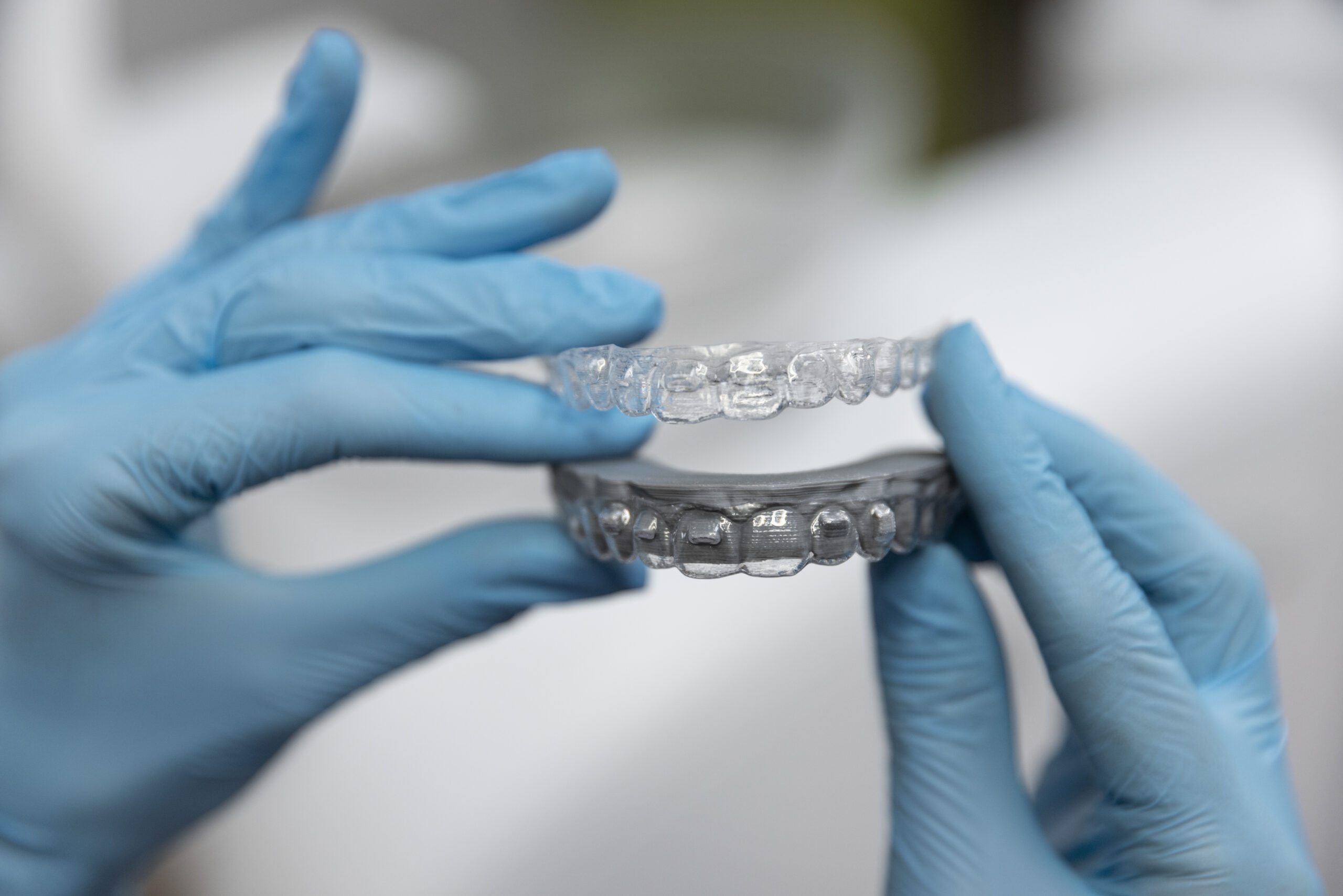 Hands holding dental aligners