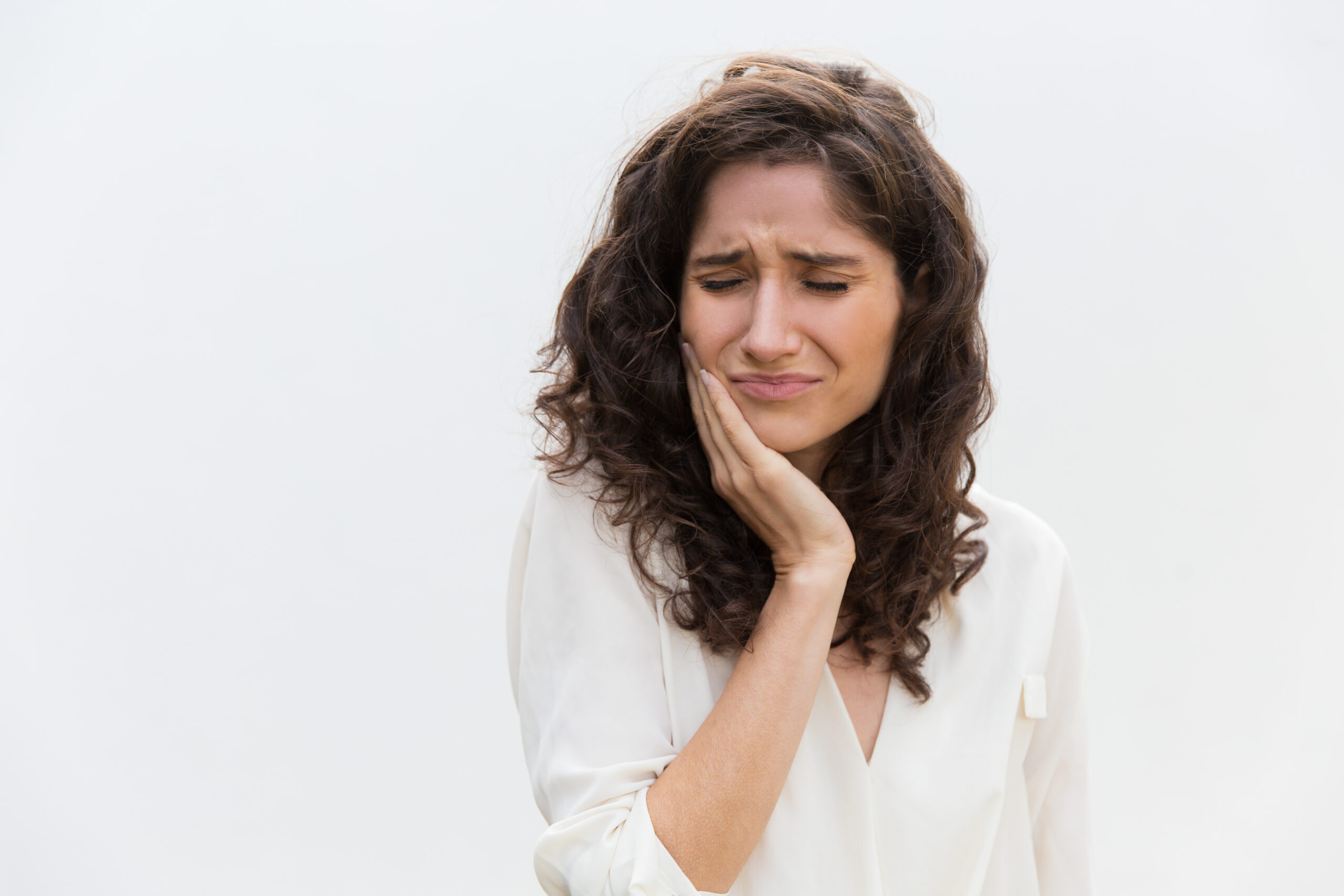 Woman holding her face in pain.
